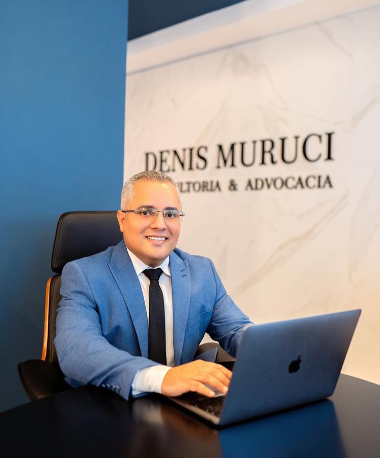 Denis Muruci na recepção, diante do letreiro da banca